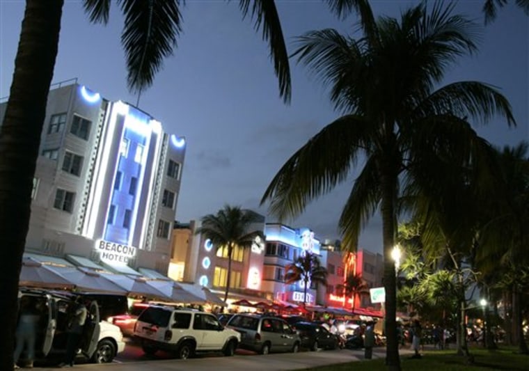 Florida lawmakers are poised to make sure online travel companies such as Expedia and Travelocity won't have to pay a larger share of local hotel taxes. Here, art deco design hotels are bathed in neon light on Ocean Drive in Miami Beach, Fla. 